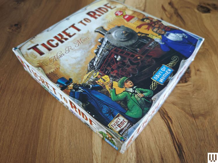 Steam train themed board game box on wooden surface