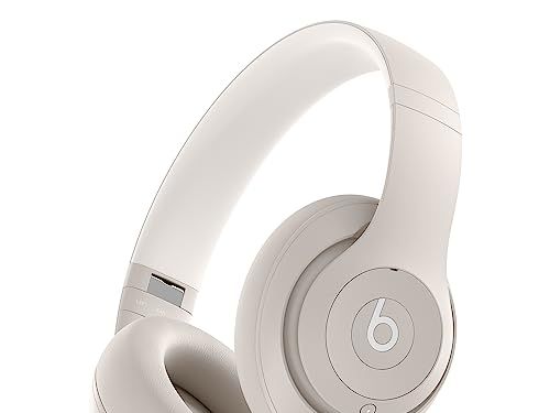 A pair of tan Beats Studio Pros floating in white space with a large lower-case "b" symbol on the outer earcup.